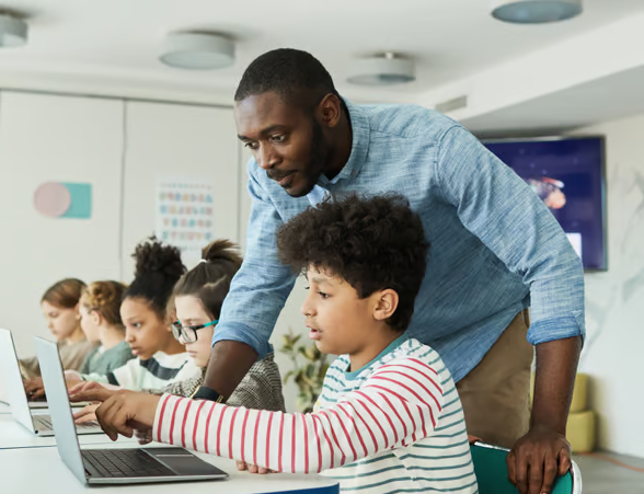 teacher helping student on laptop