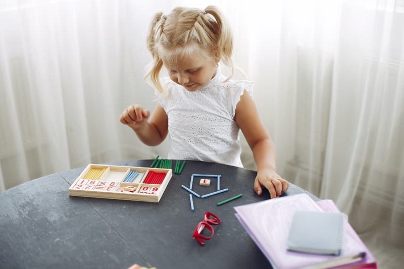 young girl playing with math toys