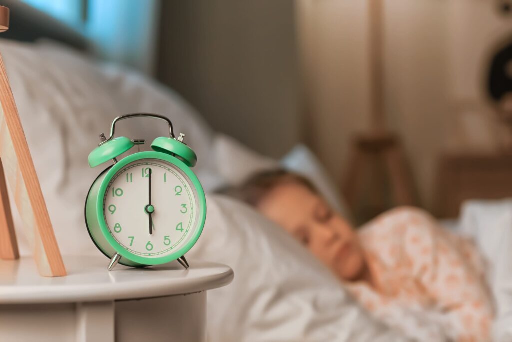 alarm clock with child sleeping in the background