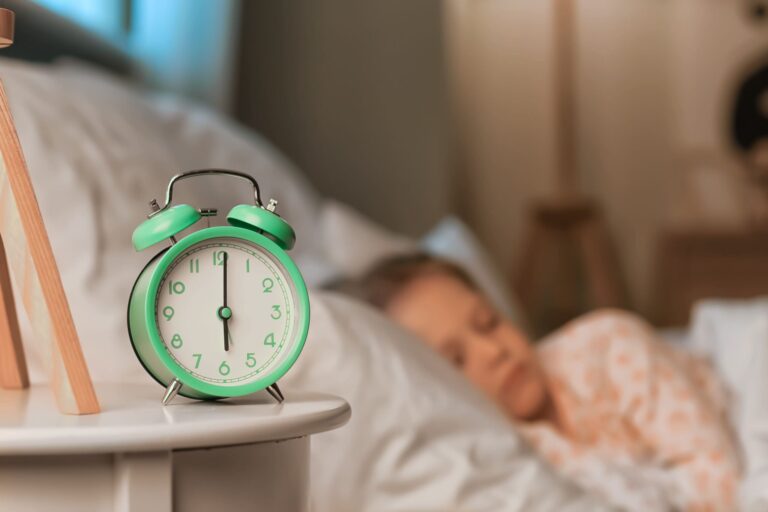 alarm clock with child sleeping in the background