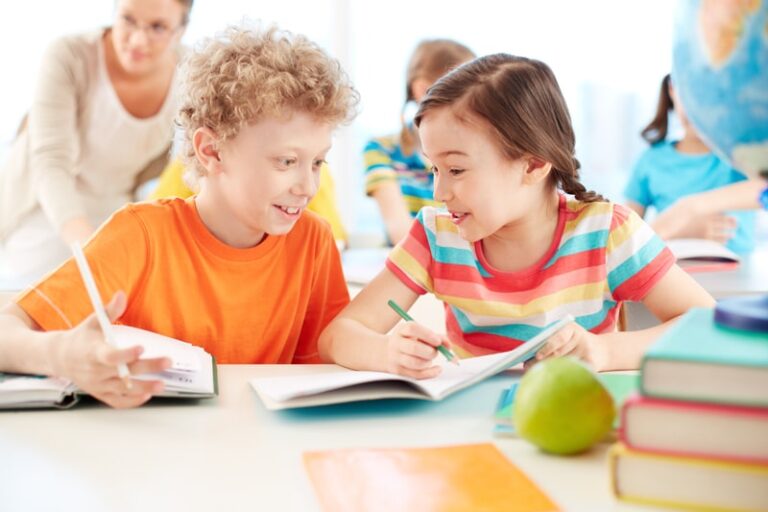 girl and boy laughing and doing school work