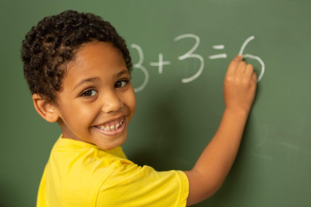 boy writing on chalkboard