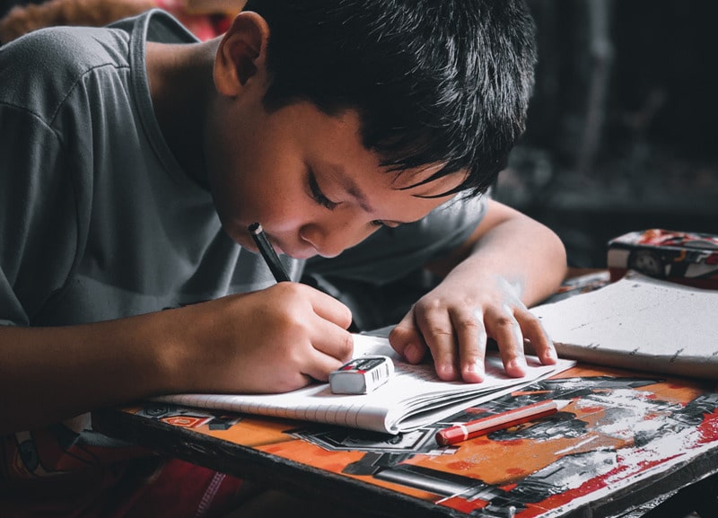 boy writing in notebook