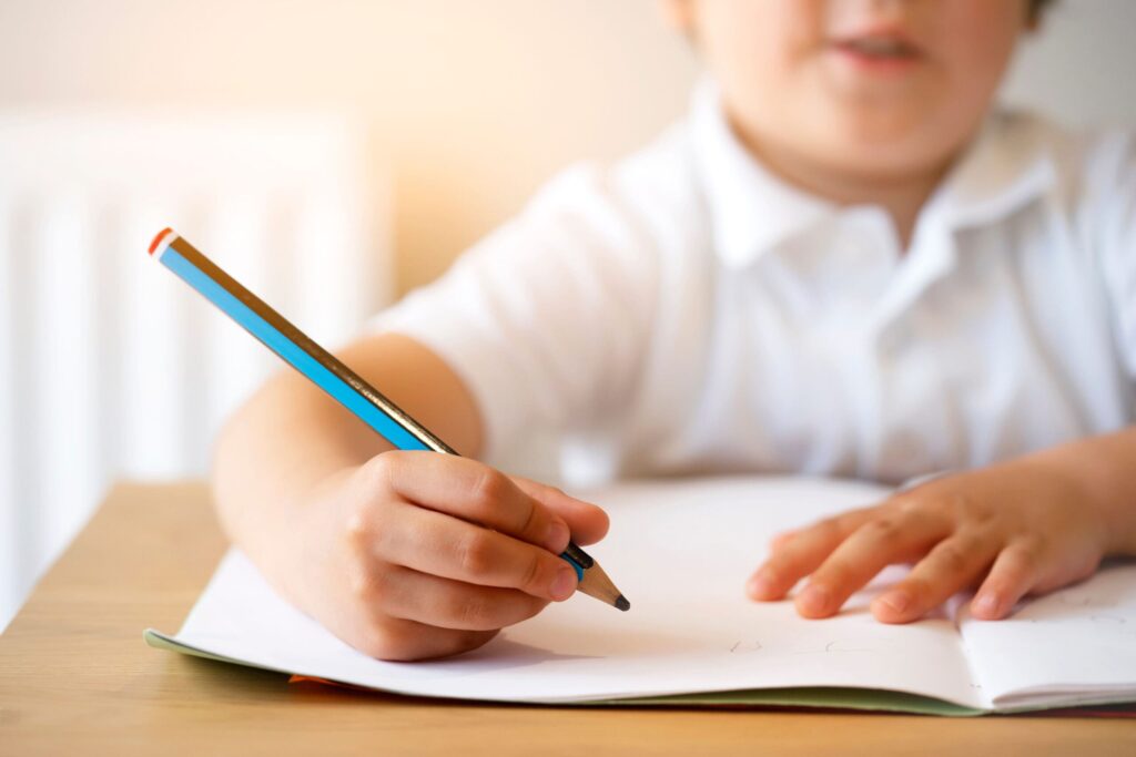 young boy writing in notebook