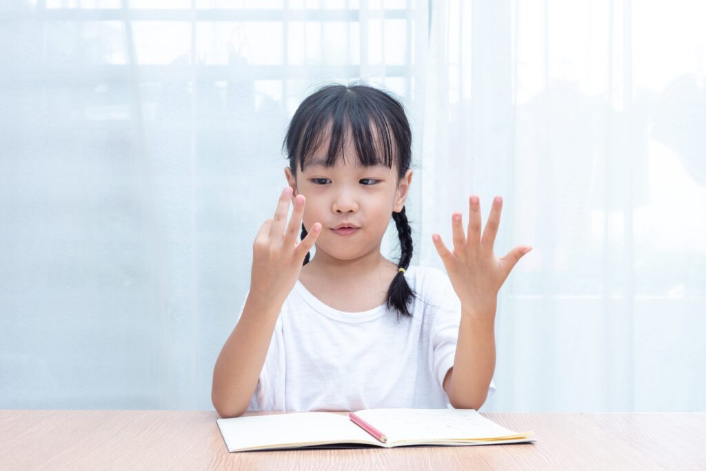 young girl using her fingers to count