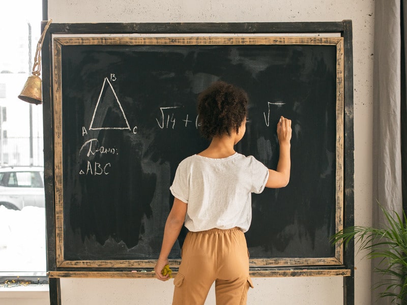 teacher writing on chalkboard