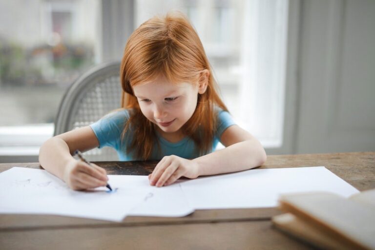 little girl writing in notebook at home