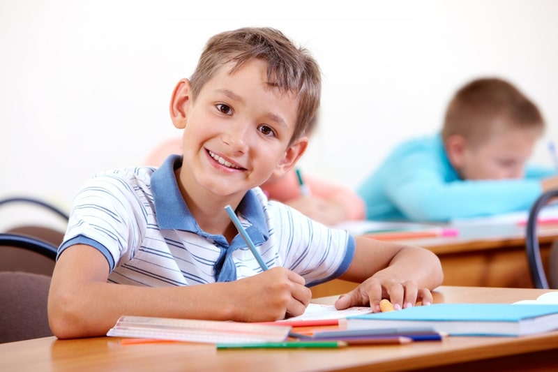 boy doing classwork and smiling