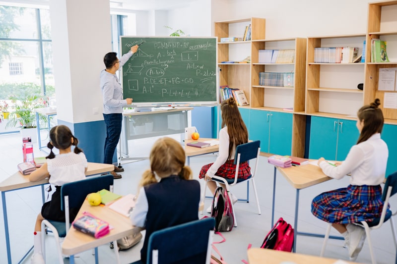 students learning from teacher in a classroom