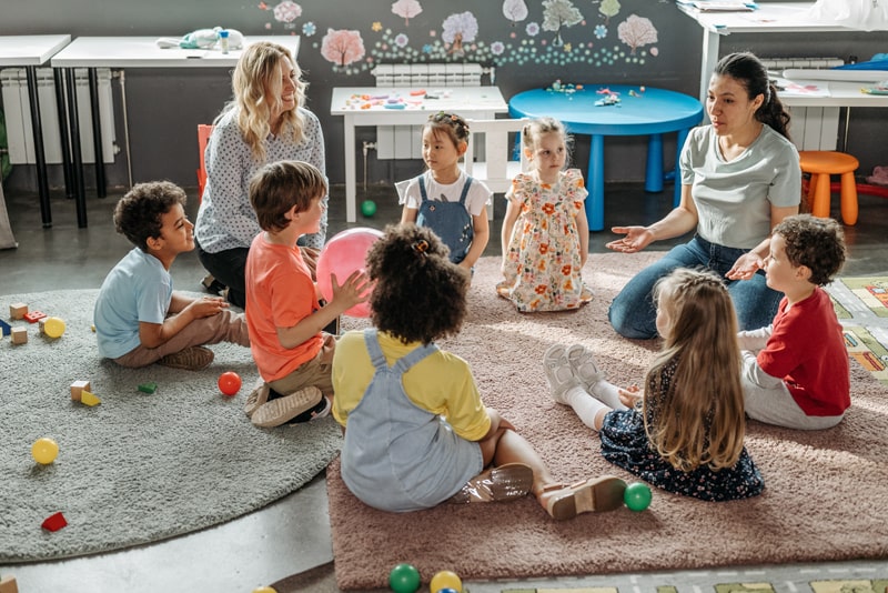 teachers and students in a floor circle