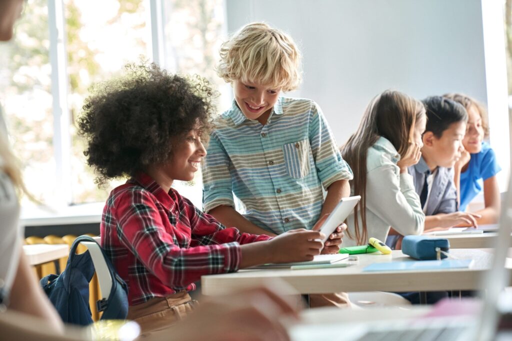 two students on a tablet in a classroom