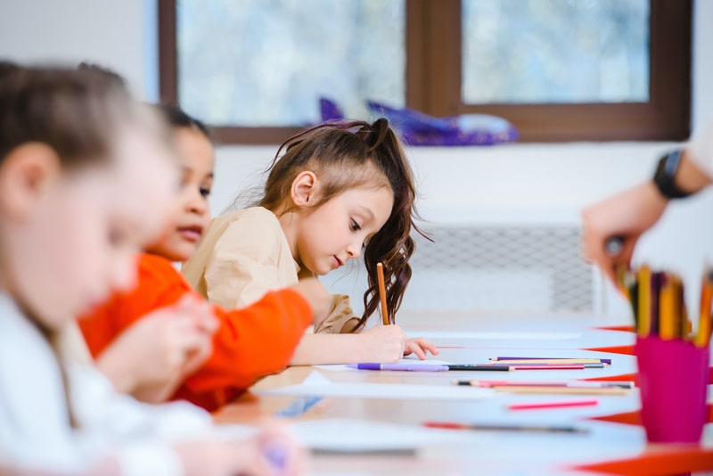 young girl drawing shapes