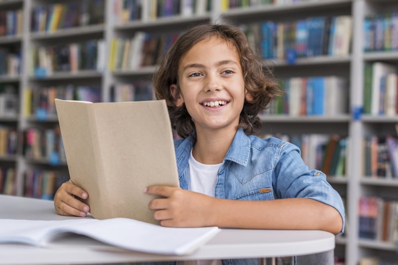 boy reading a book in the library