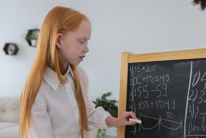 girl working on math on chalkboard