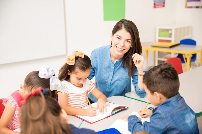 teacher helping students in classroom