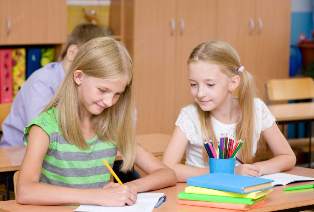 two young girls working in a classroom