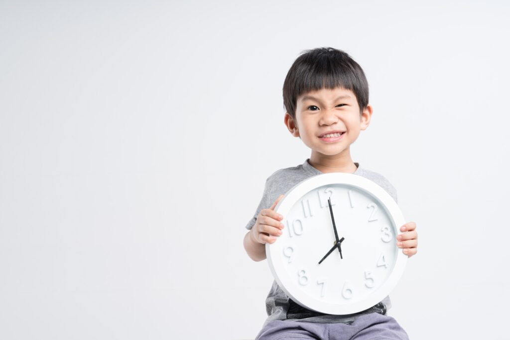 young boy holding a analog clock